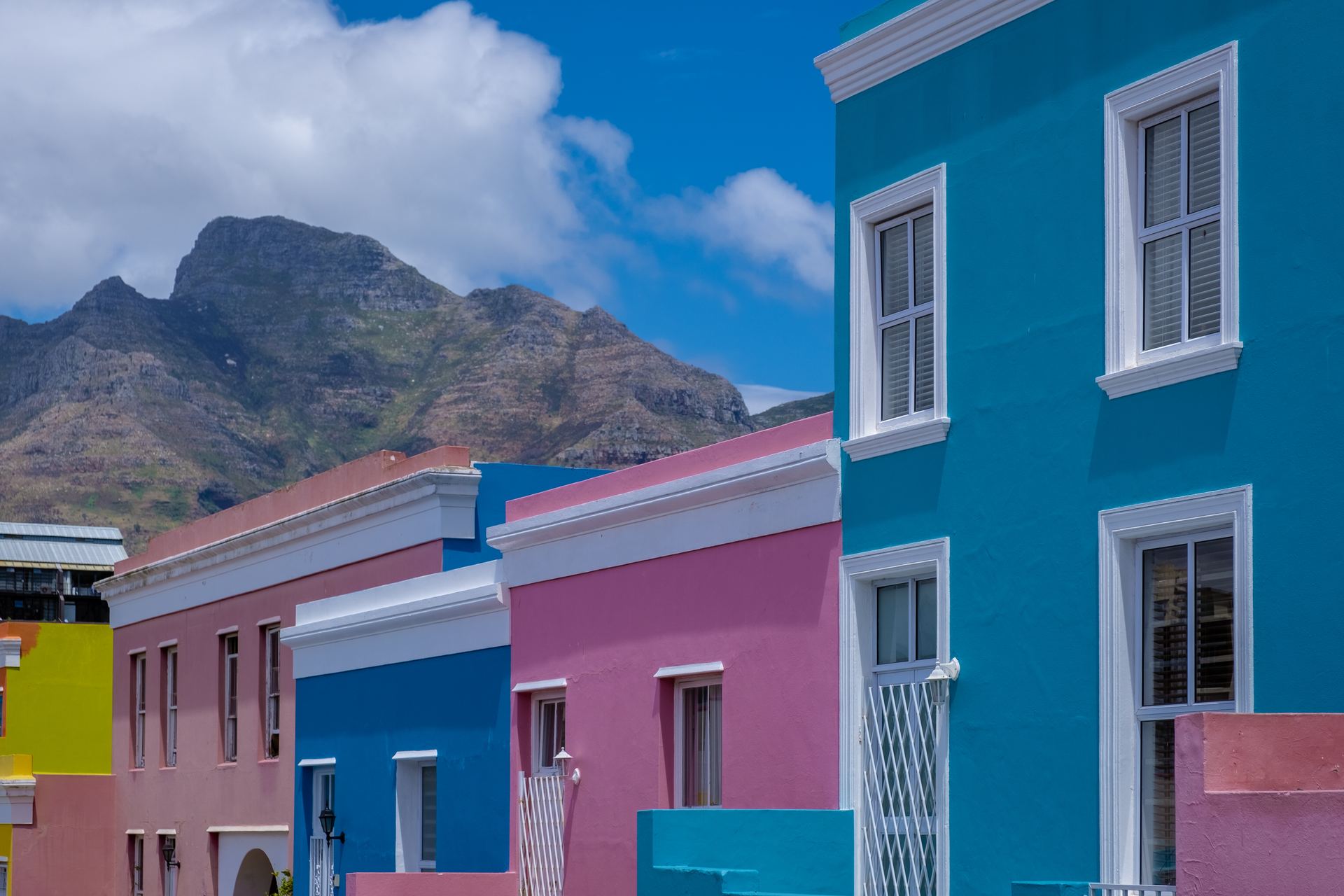 Brightly painted houses in the Bo-Kaap, Cape Town, with the hillside rising behind them.