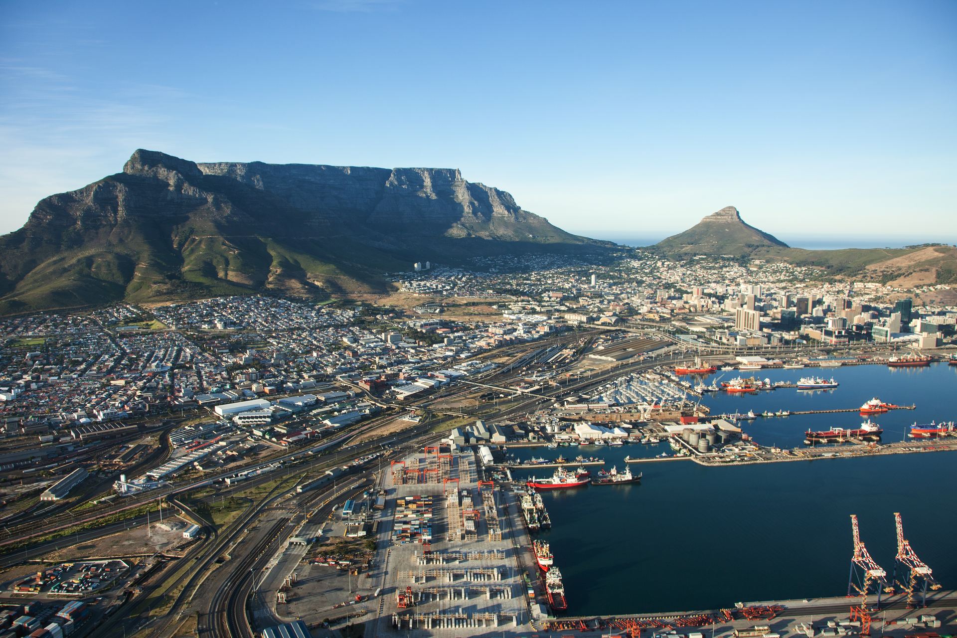 Aerial view of Cape Town harbour and its container terminal, with Table Mountain behind the city.
