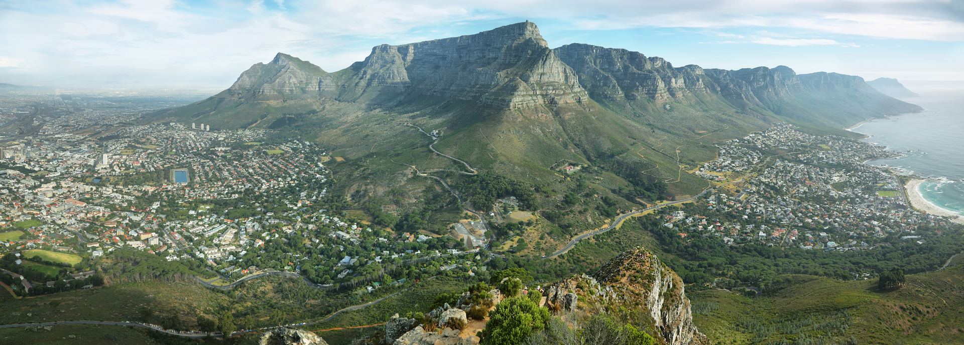 Table Mountain and the Twelve Apostles seen from above, with Cape Town spread out beneath them.