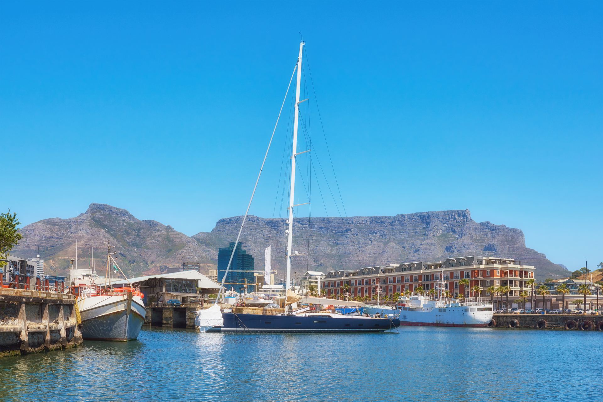 Yachts moored in Cape Town harbour with Table Mountain rising behind them.